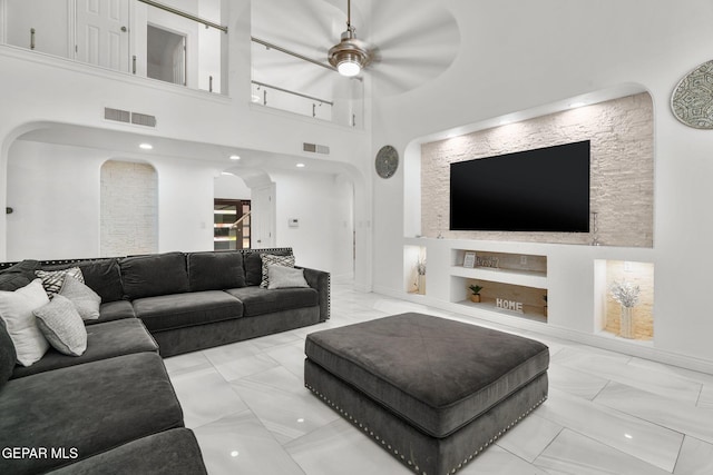12247 Chisholm Pass Dr, El Paso, TX 79936 - living room featuring arched walkways, marble finish floors, built in features, and ceiling fan