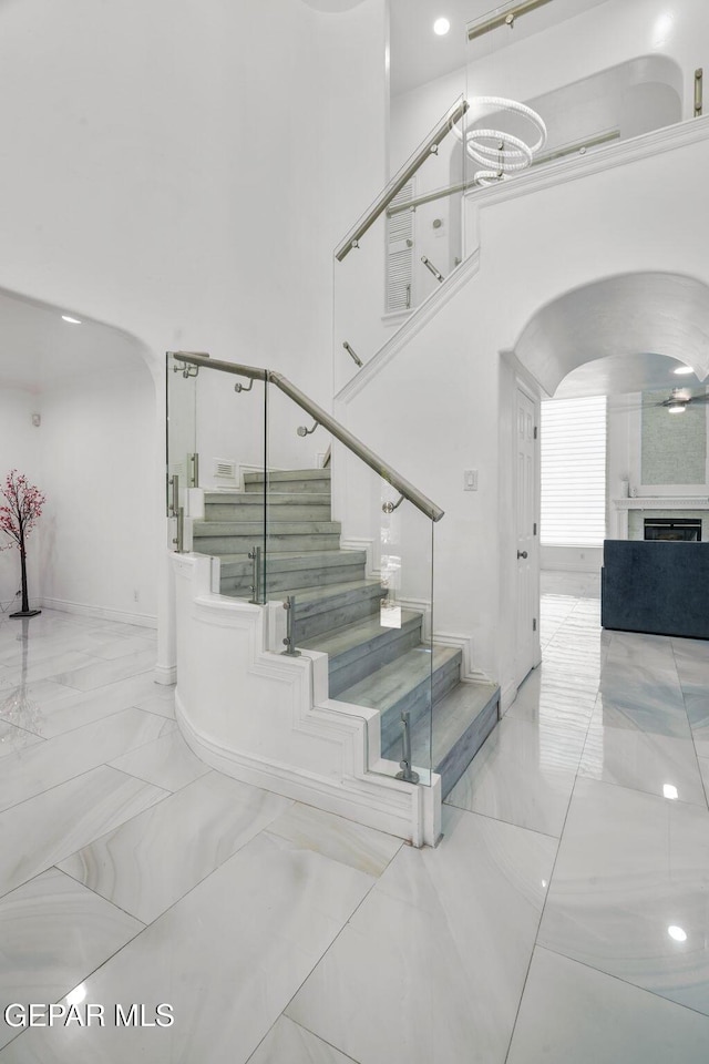 12247 Chisholm Pass Dr, El Paso, TX 79936 - stairs featuring arched walkways, marble finish floors, and a towering ceiling