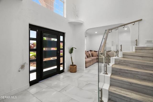 12247 Chisholm Pass Dr, El Paso, TX 79936 - foyer entrance with stairway, arched walkways, marble finish floors, and a towering ceiling