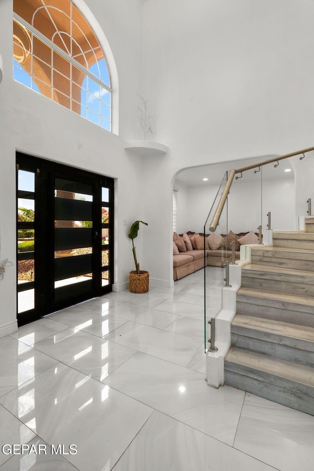 12247 Chisholm Pass Dr, El Paso, TX 79936 - foyer featuring a high ceiling, plenty of natural light, stairs, arched walkways, and marble finish flooring