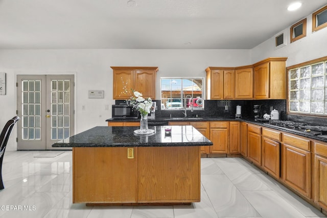 12247 Chisholm Pass Dr, El Paso, TX 79936 - kitchen featuring a center island, light marble finish floors, decorative backsplash, and dark stone counters