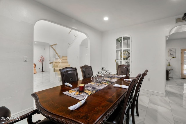 12247 Chisholm Pass Dr, El Paso, TX 79936 - dining space featuring arched walkways, stairs, light marble finish flooring, and recessed lighting