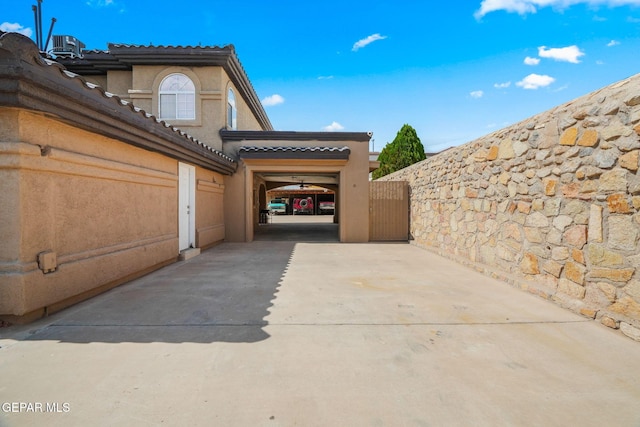 12247 Chisholm Pass Dr, El Paso, TX 79936 - view of home's exterior featuring concrete driveway, stucco siding, a tile roof, and a gate