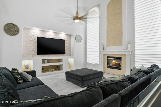 12247 Chisholm Pass Dr, El Paso, TX 79936 - living area with built in shelves, ceiling fan, a fireplace, and plenty of natural light