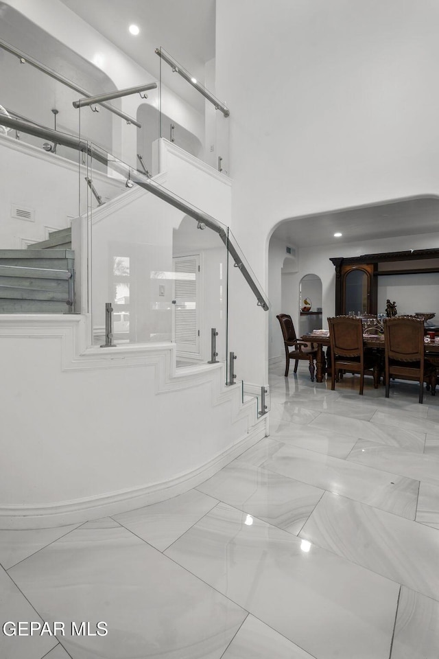 12247 Chisholm Pass Dr, El Paso, TX 79936 - stairs with arched walkways, a towering ceiling, and marble finish floors