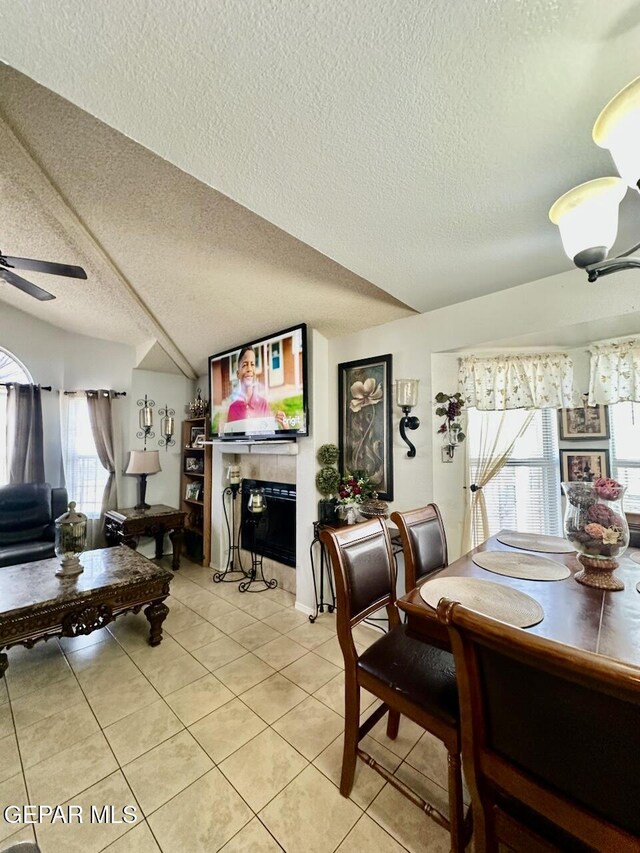 12036 Valley Quail Dr, El Paso, TX 79936 - dining space featuring a textured ceiling, light tile patterned floors, a ceiling fan, and a tiled fireplace