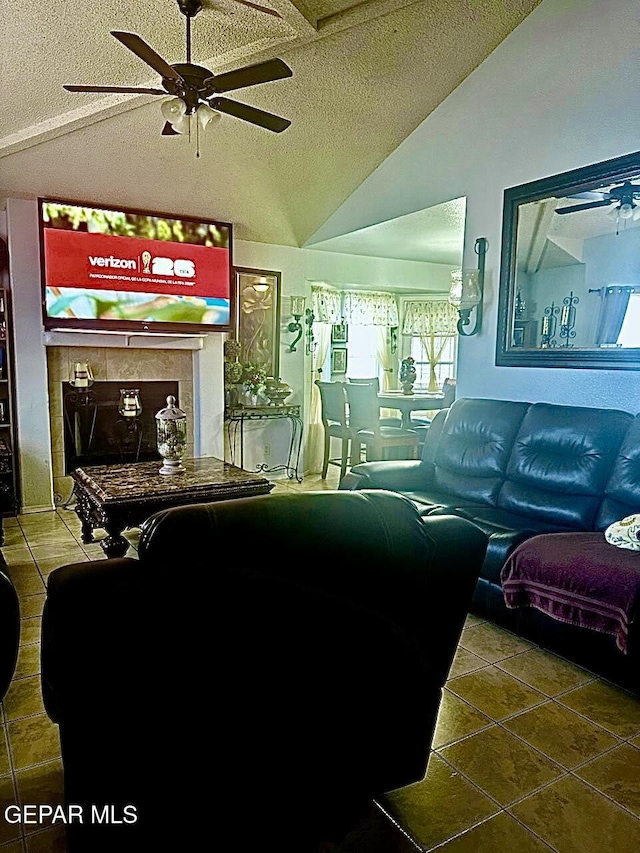 12036 Valley Quail Dr, El Paso, TX 79936 - living room with vaulted ceiling, a ceiling fan, a textured ceiling, tile patterned flooring, and a tile fireplace