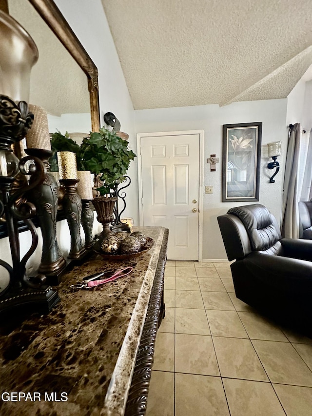 12036 Valley Quail Dr, El Paso, TX 79936 - entrance foyer featuring a textured ceiling, light tile patterned floors, and lofted ceiling