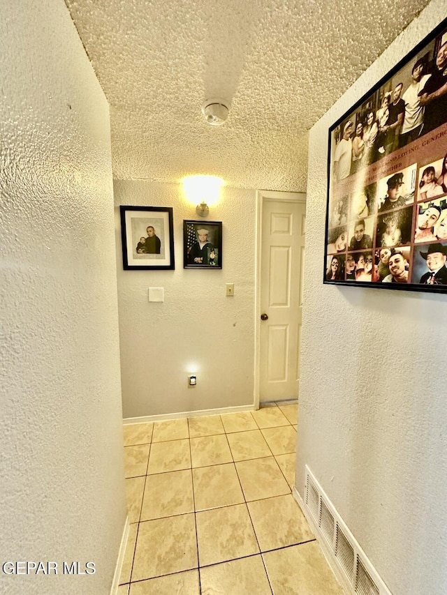 12036 Valley Quail Dr, El Paso, TX 79936 - hallway featuring a textured wall, a textured ceiling, and tile patterned flooring