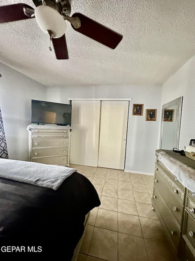 12036 Valley Quail Dr, El Paso, TX 79936 - bedroom with light tile patterned flooring, a textured ceiling, a closet, and a ceiling fan