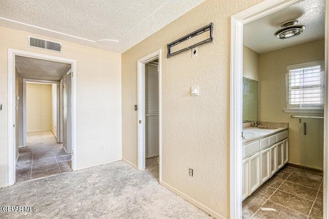 1944 Ratner Cir, El Paso, TX 79936 - corridor with a textured ceiling, a textured wall, and tile patterned flooring