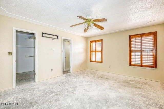1944 Ratner Cir, El Paso, TX 79936 - unfurnished bedroom featuring a textured ceiling, a spacious closet, carpet, and a ceiling fan