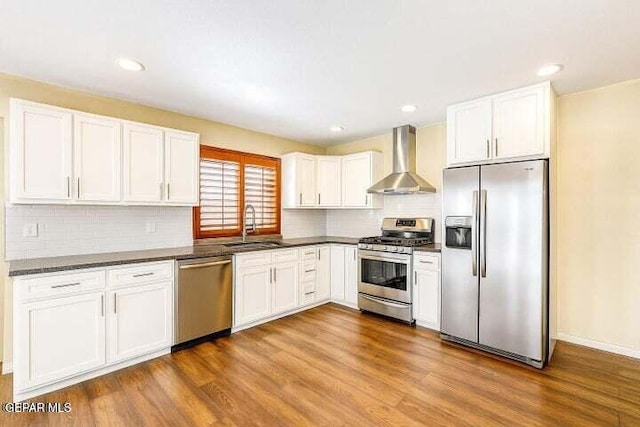 1944 Ratner Cir, El Paso, TX 79936 - kitchen with appliances with stainless steel finishes, wall chimney exhaust hood, dark countertops, tasteful backsplash, and recessed lighting