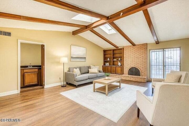 1944 Ratner Cir, El Paso, TX 79936 - living room featuring wood finished floors, a fireplace, and a skylight