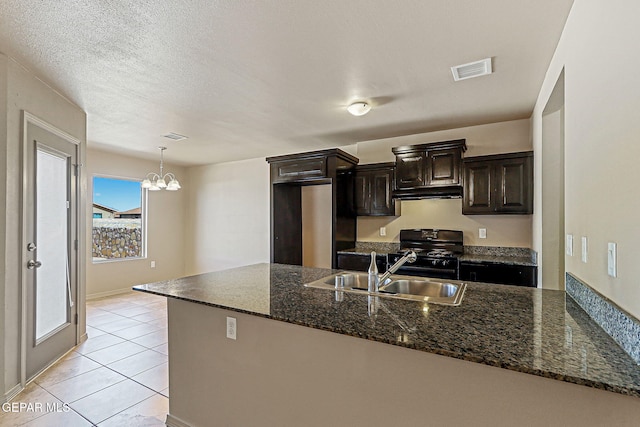 708 Cora Ruecker, El Paso, TX 79928 - kitchen with black gas range, a peninsula, a chandelier, dark stone countertops, and light tile patterned floors