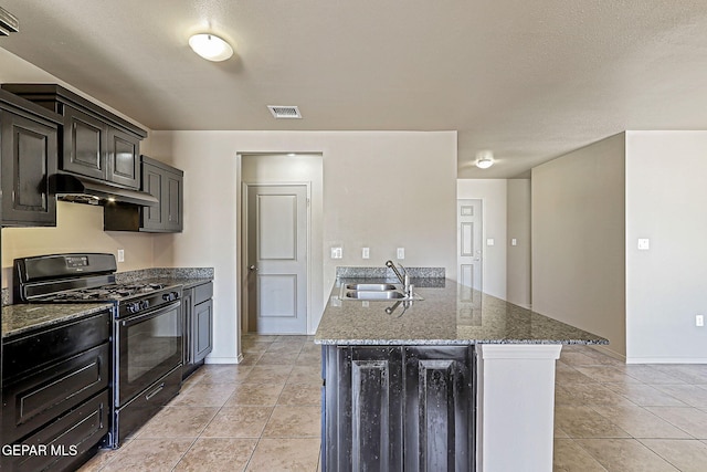 708 Cora Ruecker, El Paso, TX 79928 - kitchen featuring gas stove, under cabinet range hood, dark stone counters, light tile patterned floors, and a peninsula
