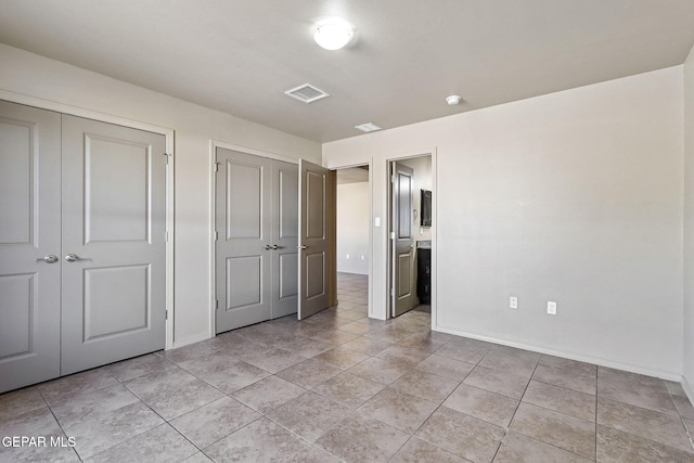708 Cora Ruecker, El Paso, TX 79928 - unfurnished bedroom with two closets, ensuite bathroom, and light tile patterned floors