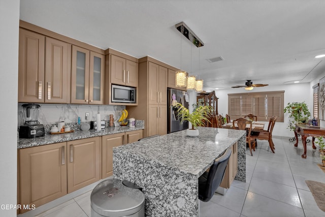11749 Socorro Rd, Socorro, TX 79927 - kitchen featuring stainless steel appliances, ceiling fan, light stone countertops, backsplash, and glass insert cabinets