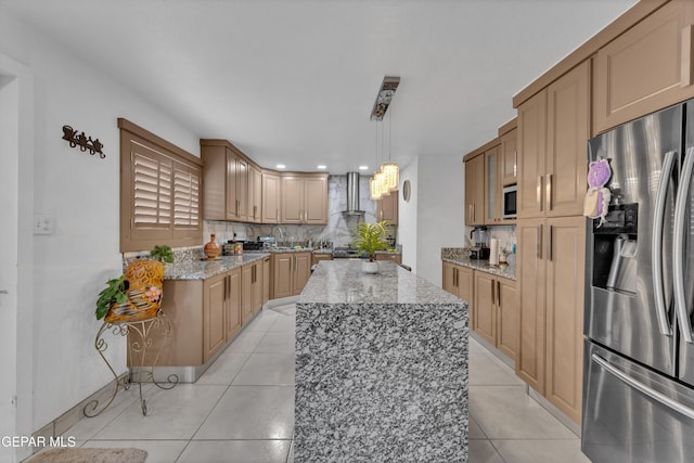 11749 Socorro Rd, Socorro, TX 79927 - kitchen with stainless steel fridge, wall chimney range hood, tasteful backsplash, light tile patterned floors, and light stone counters