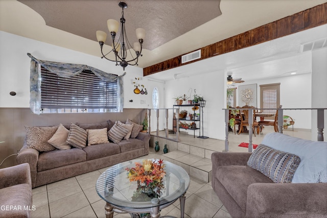 11749 Socorro Rd, Socorro, TX 79927 - living room with tile patterned floors, a chandelier, wainscoting, a ceiling fan, and a textured ceiling
