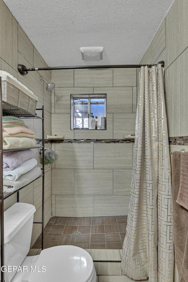 11749 Socorro Rd, Socorro, TX 79927 - bathroom featuring tiled shower and a textured ceiling