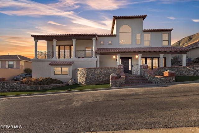 41 Sun Point Ln, El Paso, TX 79912 - mediterranean / spanish house with stucco siding, a tile roof, covered porch, and a balcony