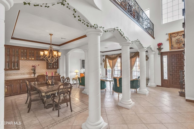 41 Sun Point Ln, El Paso, TX 79912 - dining space featuring light tile patterned floors, a chandelier, ornate columns, a tray ceiling, and crown molding
