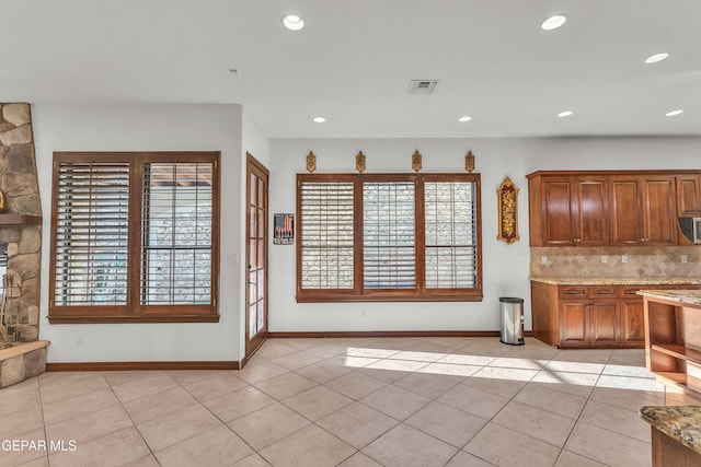 41 Sun Point Ln, El Paso, TX 79912 - kitchen featuring decorative backsplash, light tile patterned floors, recessed lighting, stainless steel microwave, and light stone counters