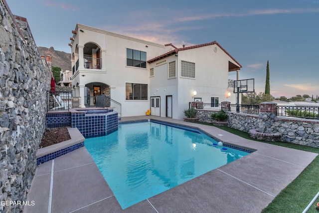 41 Sun Point Ln, El Paso, TX 79912 - rear view of property with a balcony, a pool with connected hot tub, stucco siding, and a patio area