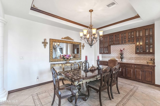 41 Sun Point Ln, El Paso, TX 79912 - dining room with inlaid floor details, a tray ceiling, a chandelier, light tile patterned flooring, and crown molding