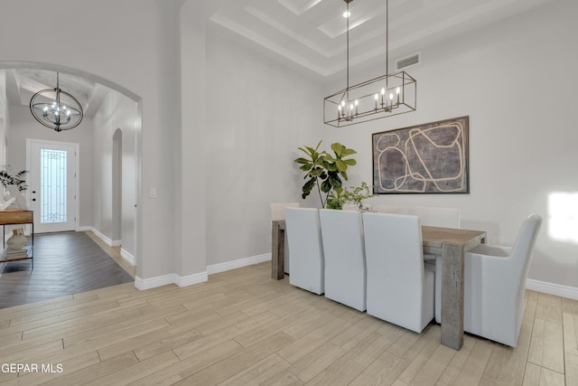 7424 Cimarron Gap Dr, El Paso, TX 79911 - dining area with a chandelier, arched walkways, light wood-style floors, and a raised ceiling
