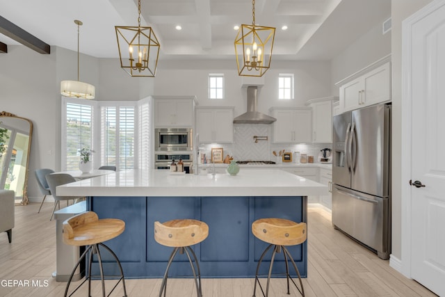 7424 Cimarron Gap Dr, El Paso, TX 79911 - kitchen with appliances with stainless steel finishes, wall chimney exhaust hood, a chandelier, light countertops, and beamed ceiling