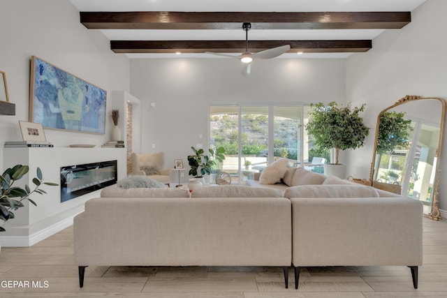 7424 Cimarron Gap Dr, El Paso, TX 79911 - living area featuring beam ceiling, a ceiling fan, a glass covered fireplace, and light wood-style floors