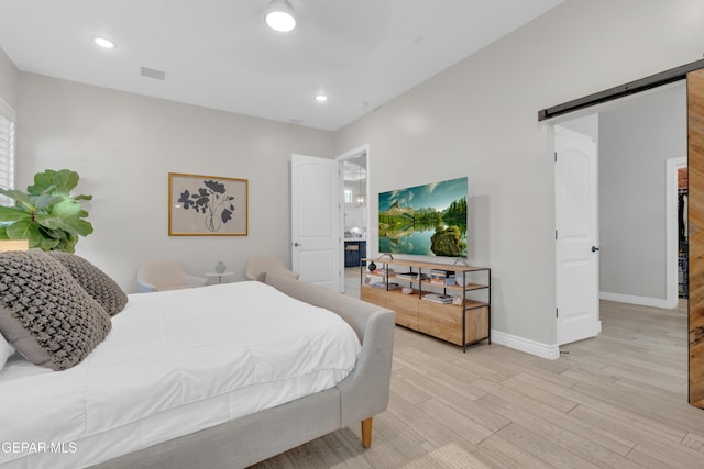 7424 Cimarron Gap Dr, El Paso, TX 79911 - bedroom featuring a barn door, light wood finished floors, and recessed lighting