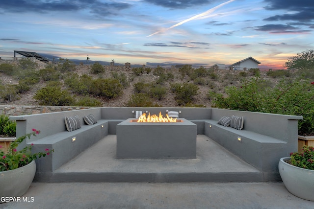 7424 Cimarron Gap Dr, El Paso, TX 79911 - patio terrace at dusk featuring an outdoor living space with a fire pit and a patio