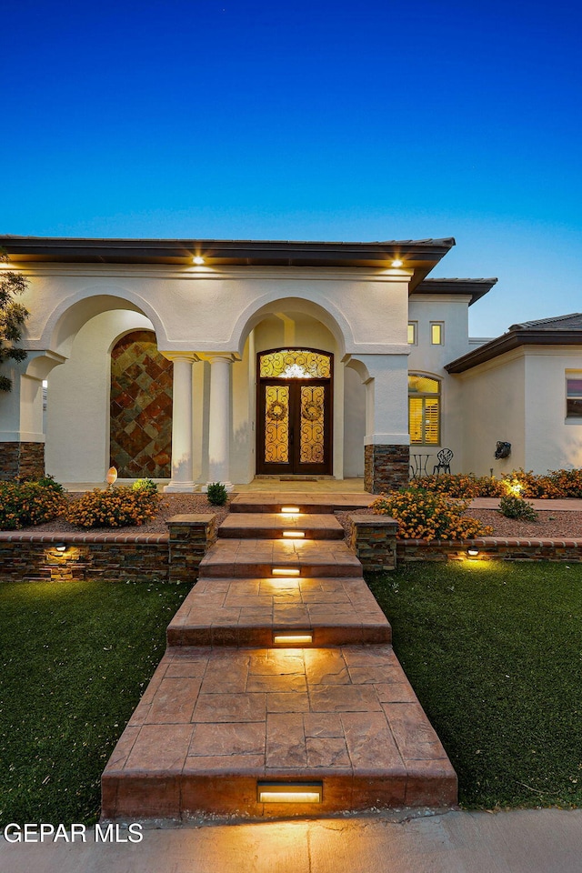 12289 Freshwater Dr, El Paso, TX 79928 - view of exterior entry featuring covered porch, stucco siding, and a lawn