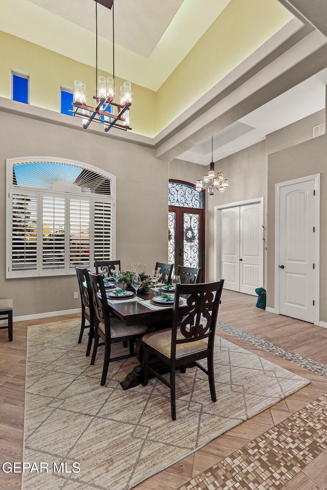 12289 Freshwater Dr, El Paso, TX 79928 - dining space featuring a chandelier, a towering ceiling, and wood finished floors