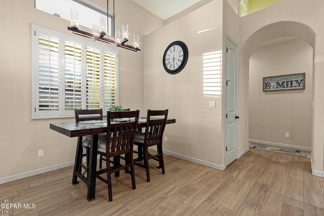 12289 Freshwater Dr, El Paso, TX 79928 - dining space featuring wood finished floors, arched walkways, a chandelier, and a towering ceiling