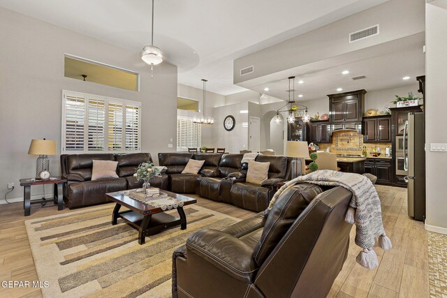 12289 Freshwater Dr, El Paso, TX 79928 - living room featuring light wood finished floors, a chandelier, arched walkways, ceiling fan, and recessed lighting