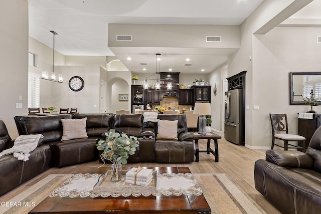 12289 Freshwater Dr, El Paso, TX 79928 - living area with a chandelier, light wood-style flooring, and arched walkways