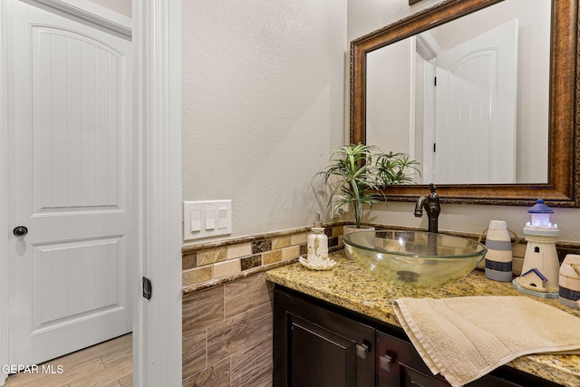 12289 Freshwater Dr, El Paso, TX 79928 - bathroom with vanity, tile walls, wainscoting, a textured wall, and wood finished floors