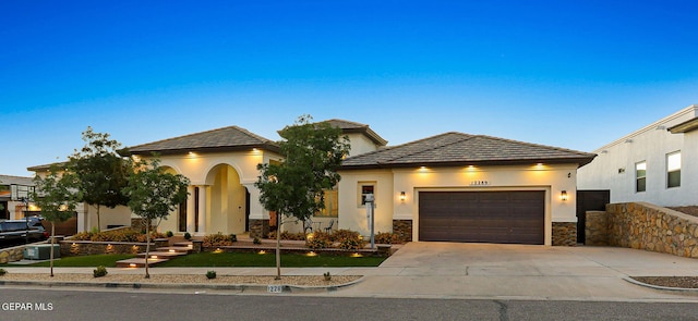 12289 Freshwater Dr, El Paso, TX 79928 - view of front of house featuring concrete driveway, a garage, stucco siding, stone siding, and a tile roof