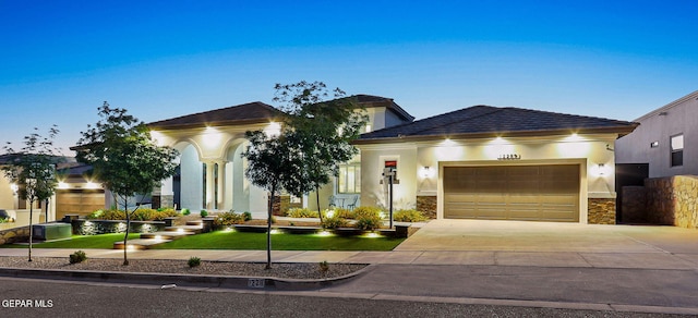 12289 Freshwater Dr, El Paso, TX 79928 - view of front of property featuring a garage, driveway, stucco siding, and stone siding