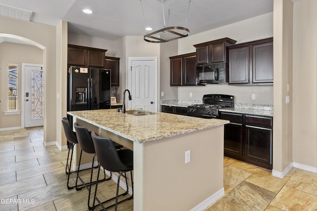 2057A Howard Jones, El Paso, TX 79938 - kitchen with black appliances, arched walkways, dark brown cabinets, a kitchen breakfast bar, and recessed lighting