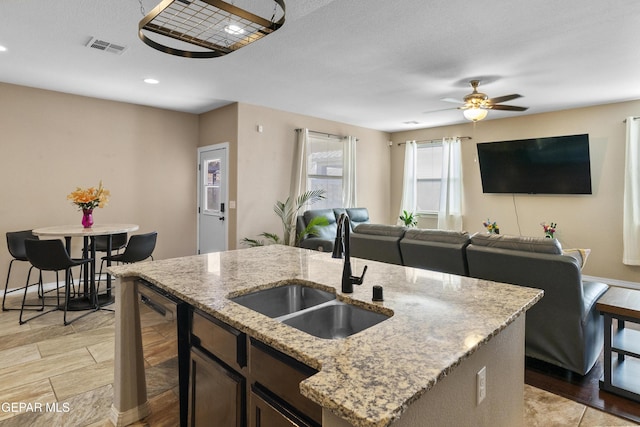 2057A Howard Jones, El Paso, TX 79938 - kitchen featuring dishwashing machine, ceiling fan, open floor plan, light wood-style flooring, and light stone countertops