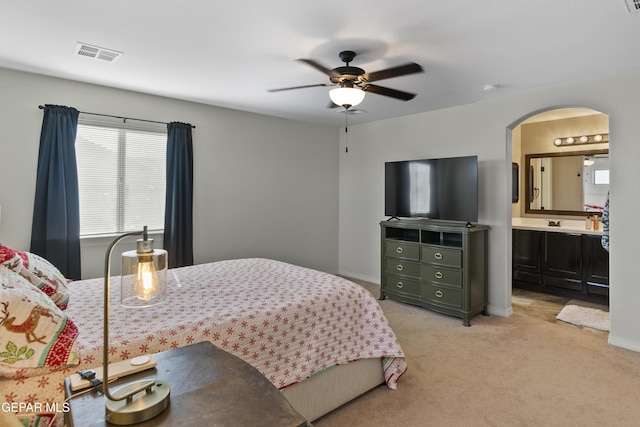 2057A Howard Jones, El Paso, TX 79938 - bedroom with arched walkways, light carpet, connected bathroom, and a ceiling fan