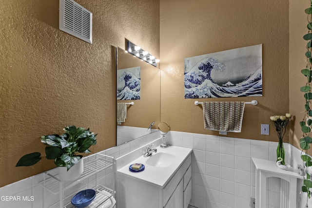 34 Kingery Dr, El Paso, TX 79902 - bathroom featuring vanity, tile walls, wainscoting, and a textured wall