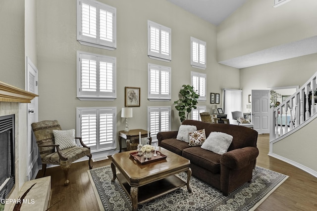 34 Kingery Dr, El Paso, TX 79902 - living room with a high ceiling, stairway, a tile fireplace, and wood finished floors
