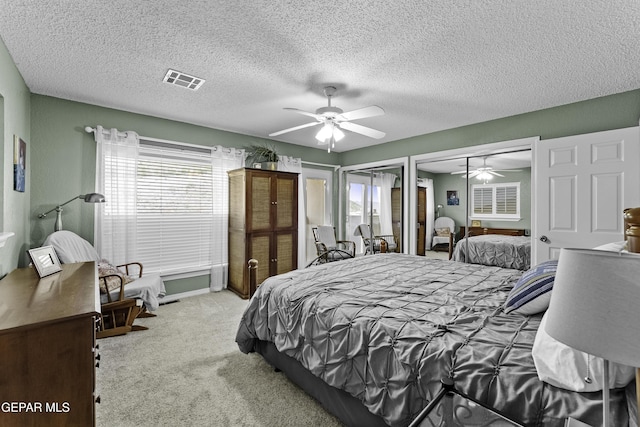 34 Kingery Dr, El Paso, TX 79902 - bedroom featuring carpet flooring, two closets, ceiling fan, and a textured ceiling