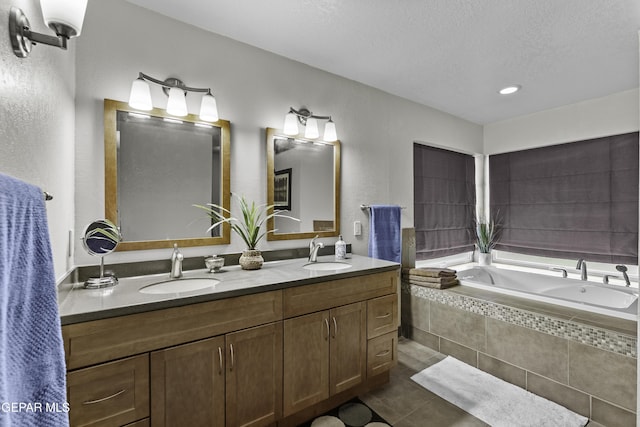 34 Kingery Dr, El Paso, TX 79902 - bathroom featuring double vanity, tile patterned floors, a garden tub, a textured ceiling, and a textured wall